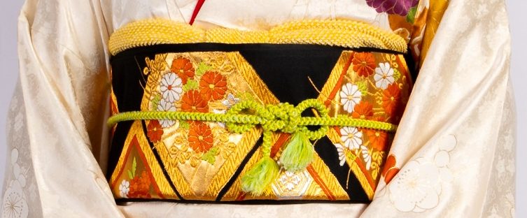 Models in Yukata im Sonnenblumenfeld Zwei Frauen in bunter Japanischer Kleidung halten Fächer und stehen zwischen Sonnenblumen.